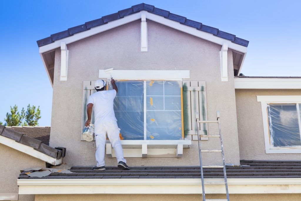 man painting a window frame
